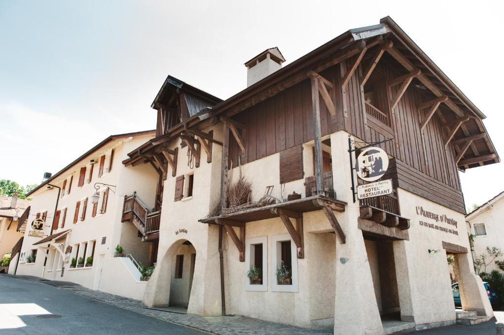 - un bâtiment en bois avec un balcon dans une rue dans l'établissement Auberge d'Anthy, à Anthy