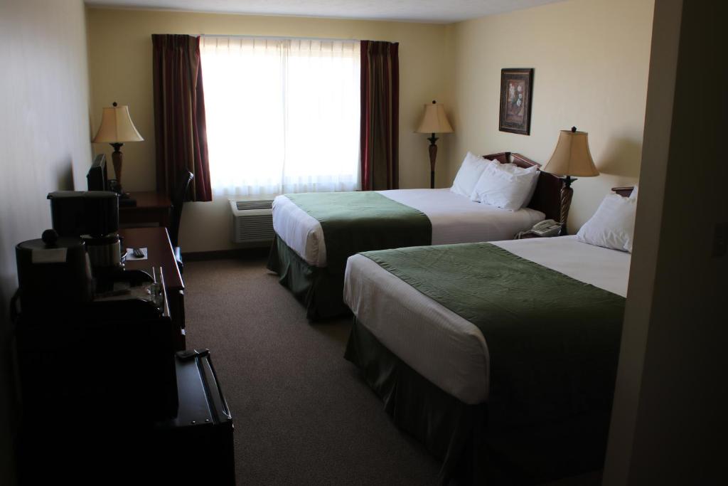 ein Hotelzimmer mit 2 Betten und einem Fenster in der Unterkunft The Edgewood Hotel and Suites in Fairbury