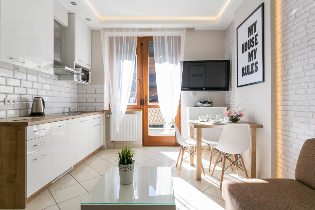 a kitchen and a living room with a table at VIP Apartamenty Tetmajera Centrum 2 in Zakopane