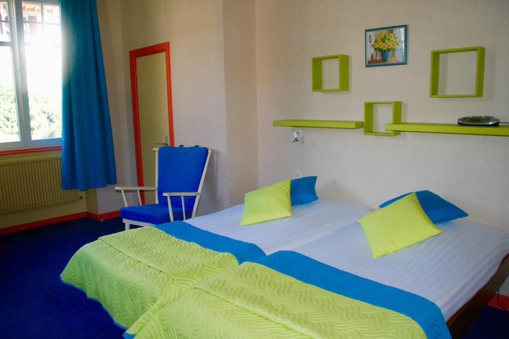 Muhlbach-sur-MunsterにあるVilla Du Sendenbachのベッドルーム(大型ベッド1台、青い椅子付)