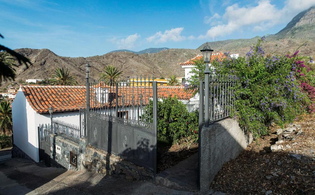 a gate to a house with mountains in the background at San Borondón in Alojera
