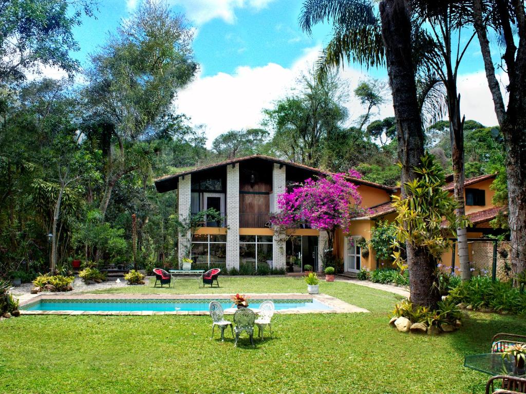 a house with a swimming pool in the yard at Pousada Villa Jambo in Petrópolis