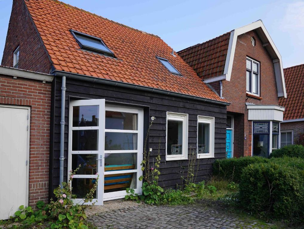 una casa negra con techo rojo en Studio Zilt, en Vlissingen