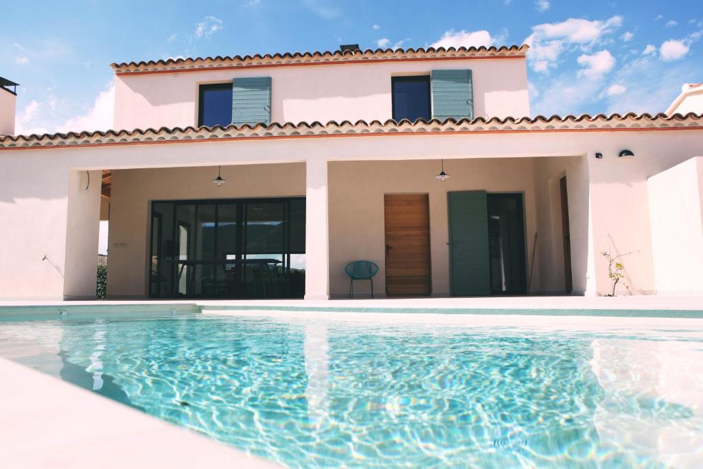 a villa with a swimming pool in front of a house at Le 27 in Malaucène