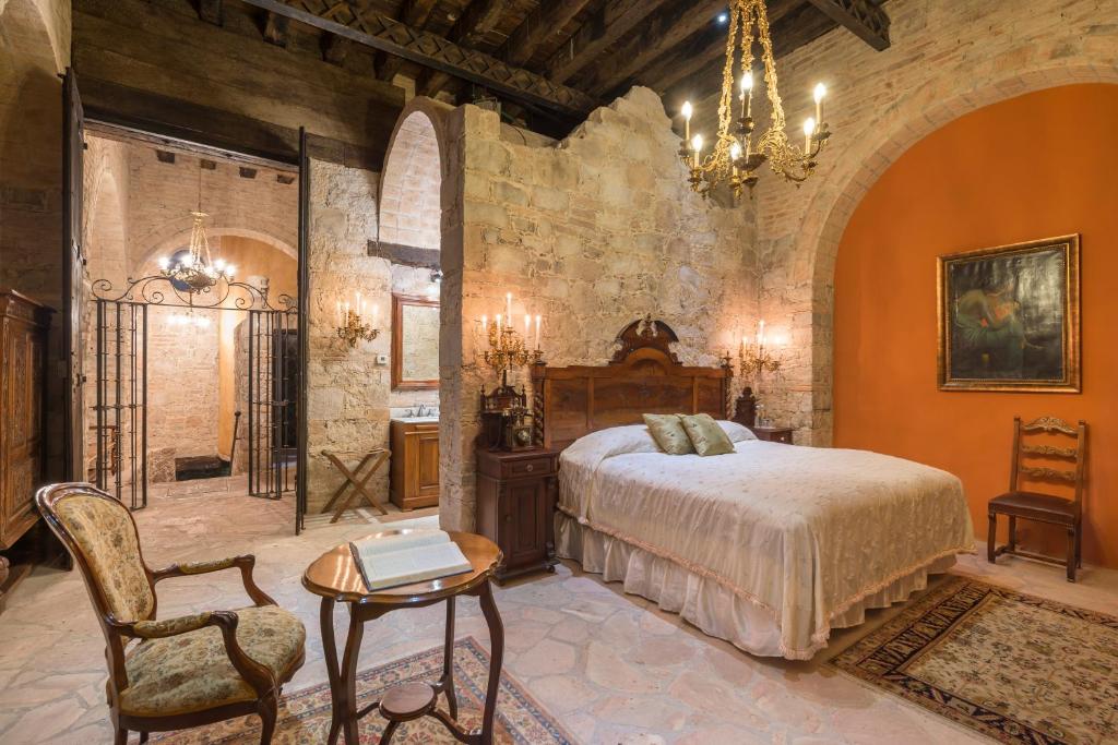- une chambre avec un lit, une table et un lustre dans l'établissement Hotel Museo Palacio de San Agustin, à San Luis Potosí