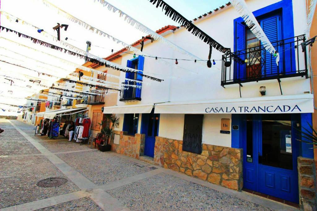 ein Gebäude mit blauen Türen und Fenstern auf einer Straße in der Unterkunft La Trancada in Tabarca