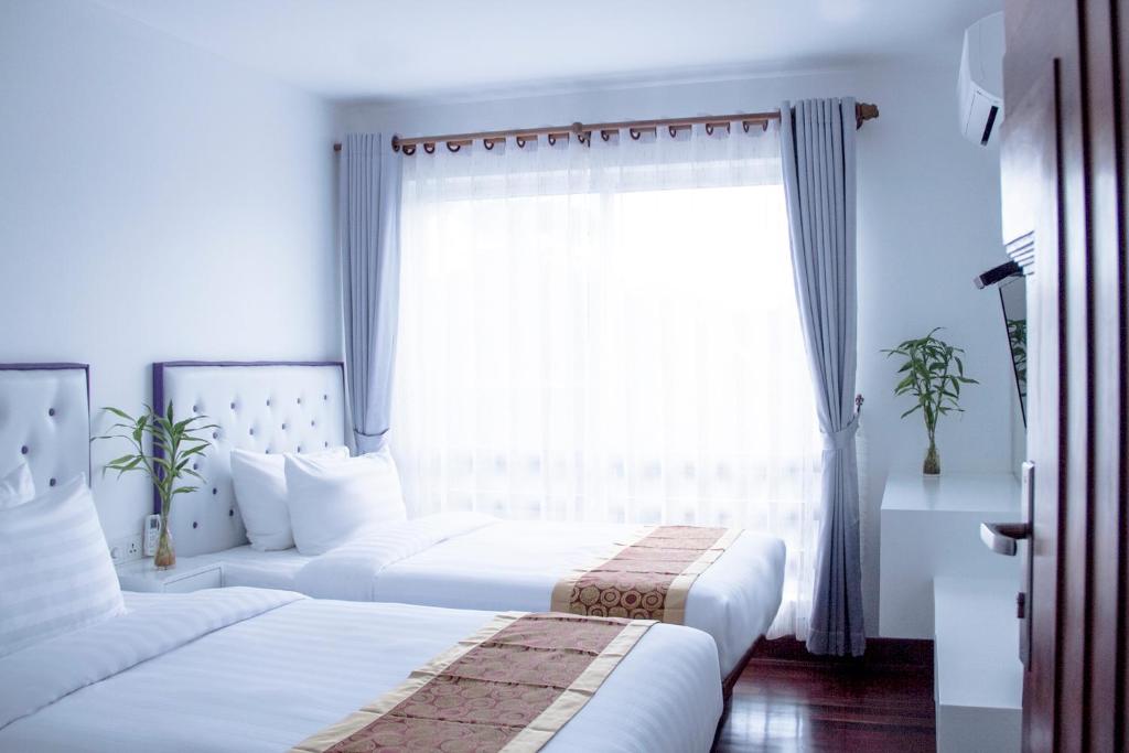 Postel nebo postele na pokoji v ubytování Zita Angkor Hotel