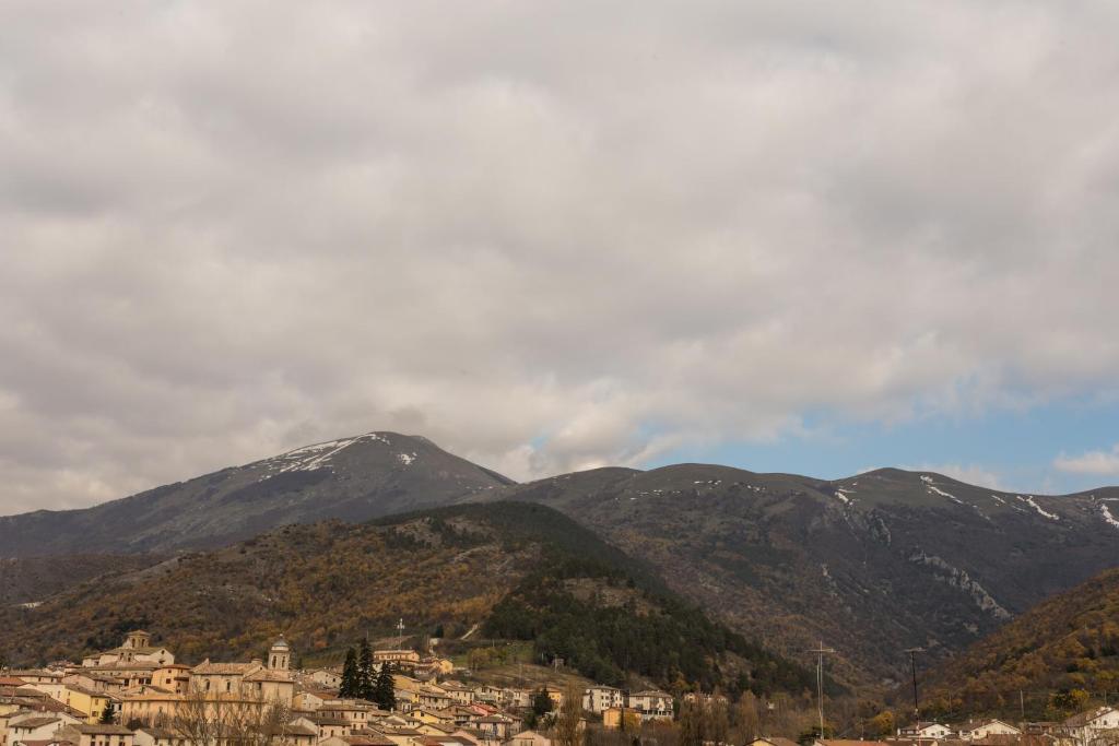 a small town in front of a mountain range at Panoramic Apartment Sigillo in Sigillo
