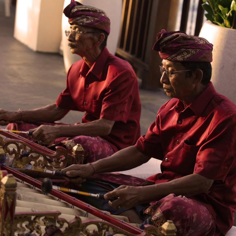 two men in red uniforms sitting on a boat at Anantara Uluwatu Bali Resort in Uluwatu