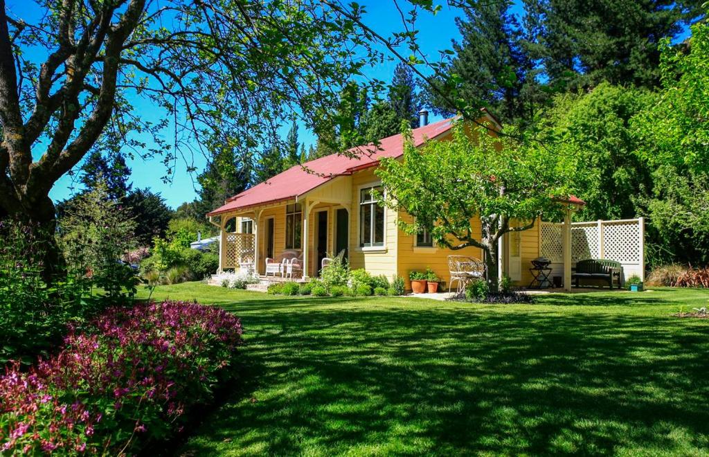 uma casa amarela com um telhado vermelho num quintal em Leader Valley Cottage - A Tranquil Retreat For Two em Mendip Hills