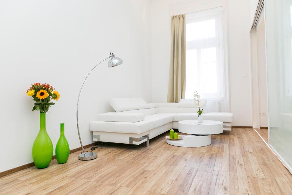 a white living room with a white couch and vases at Convenience & Chic by the Basilica in Budapest