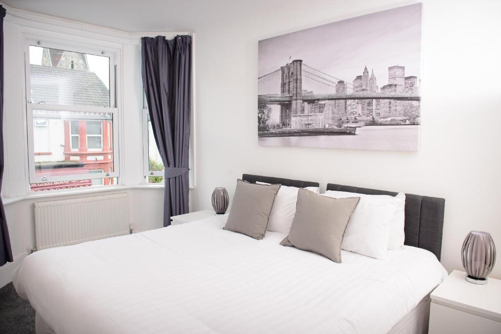 a bedroom with a white bed with a window at The Claremont in Southampton