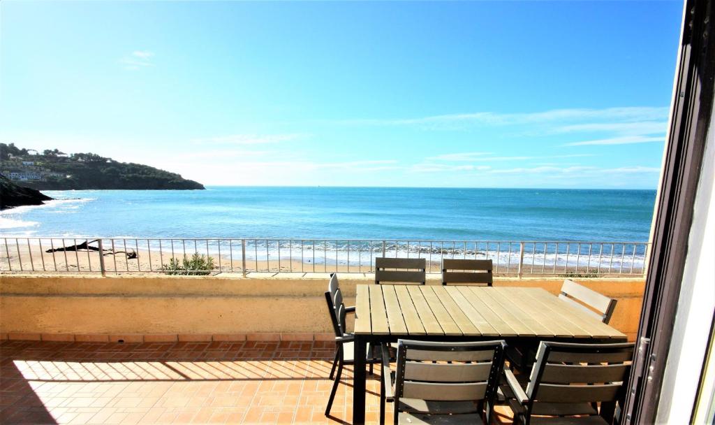 a table and chairs on a balcony with a view of the beach at Albatros in Capoliveri