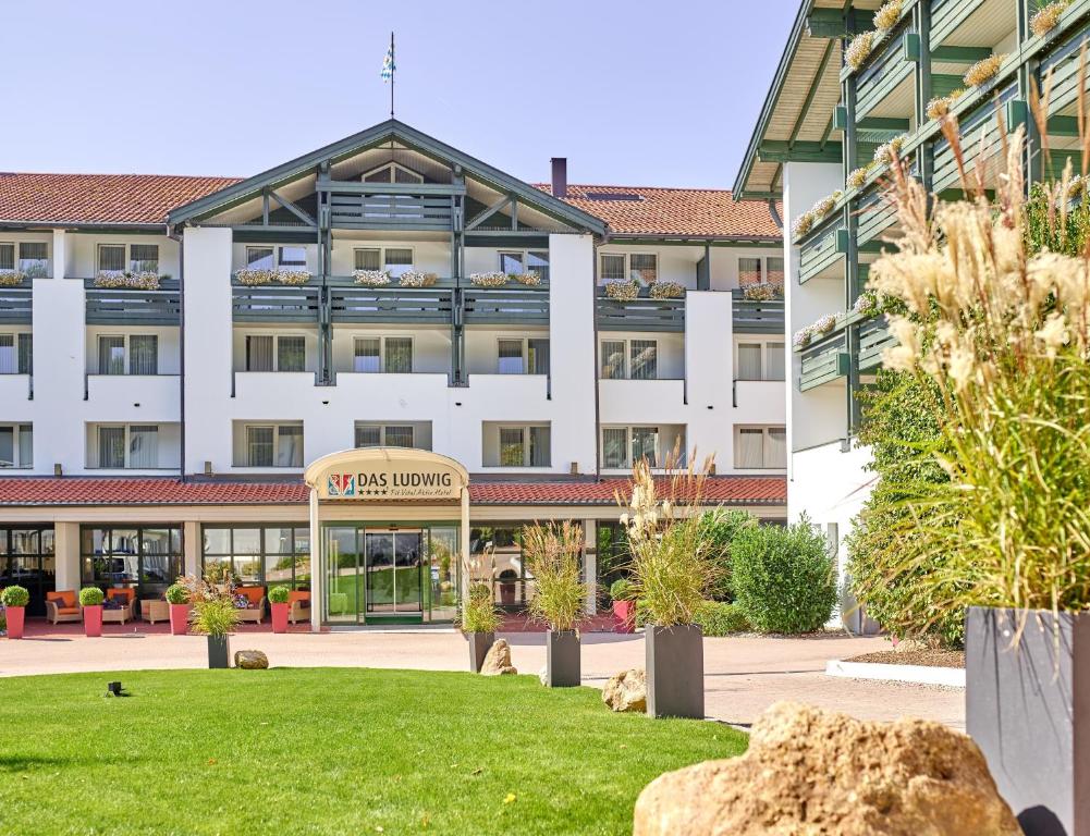un grand bâtiment blanc avec une pelouse devant lui dans l'établissement Fit Vital Aktiv Hotel DAS LUDWIG, à Bad Griesbach im Rottal