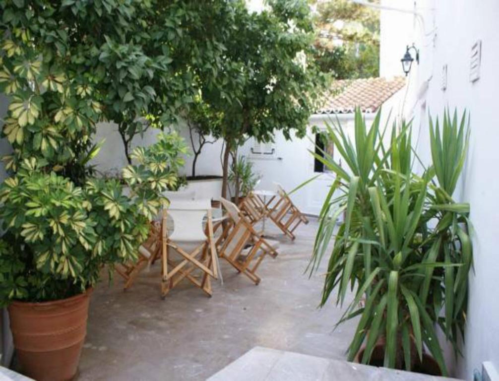 a patio with chairs and trees and plants at Andrea Pension in Hydra