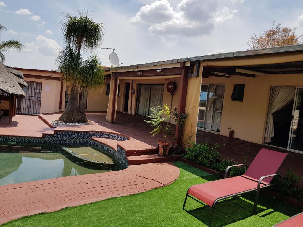 a yard with a chair and a swimming pool at Ethen Guesthouse in Polokwane