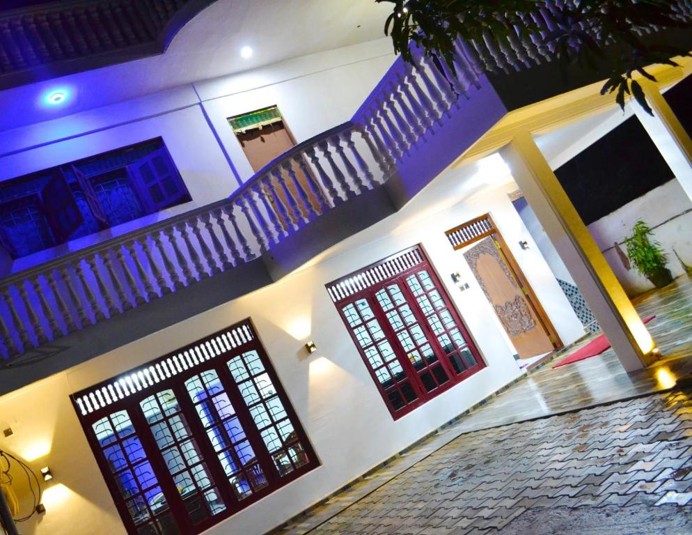 a building with two doors and a staircase with lights at Hewage Resort in Anuradhapura