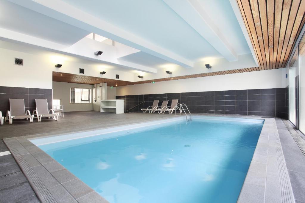 a large swimming pool in a hotel room with a pool at Odalys City Lyon Confluence in Lyon