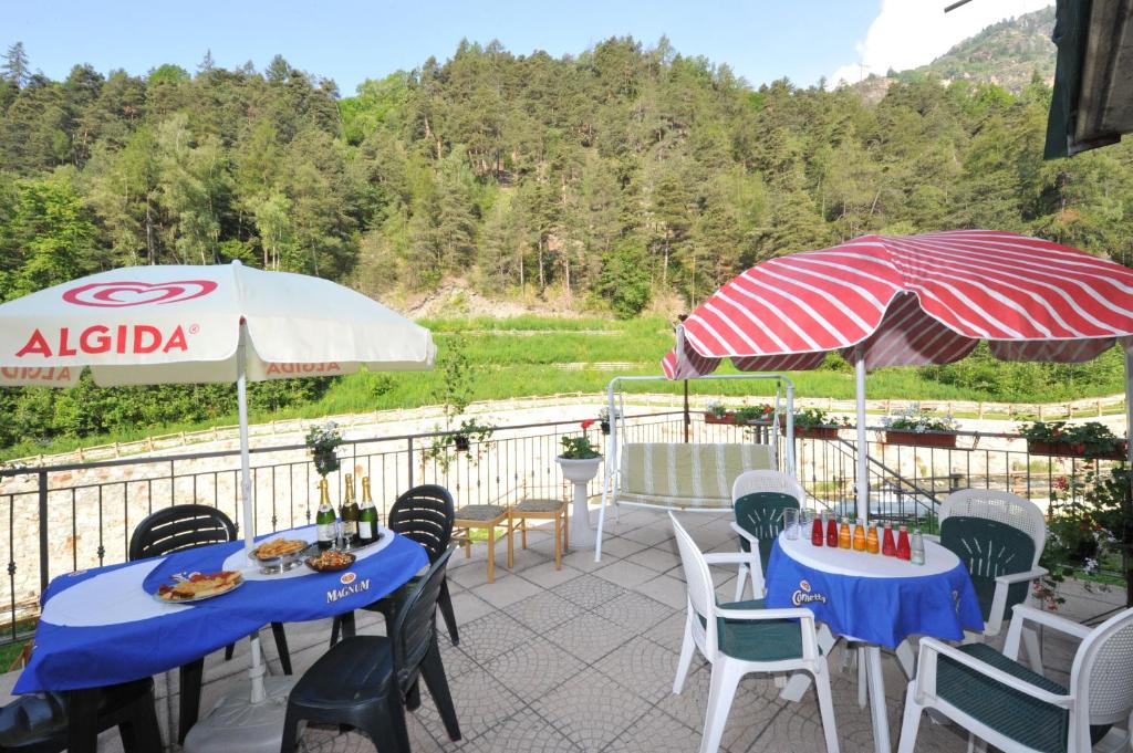 a patio with tables and chairs and an umbrella at Locanda monte cervino in Antey-Saint-André