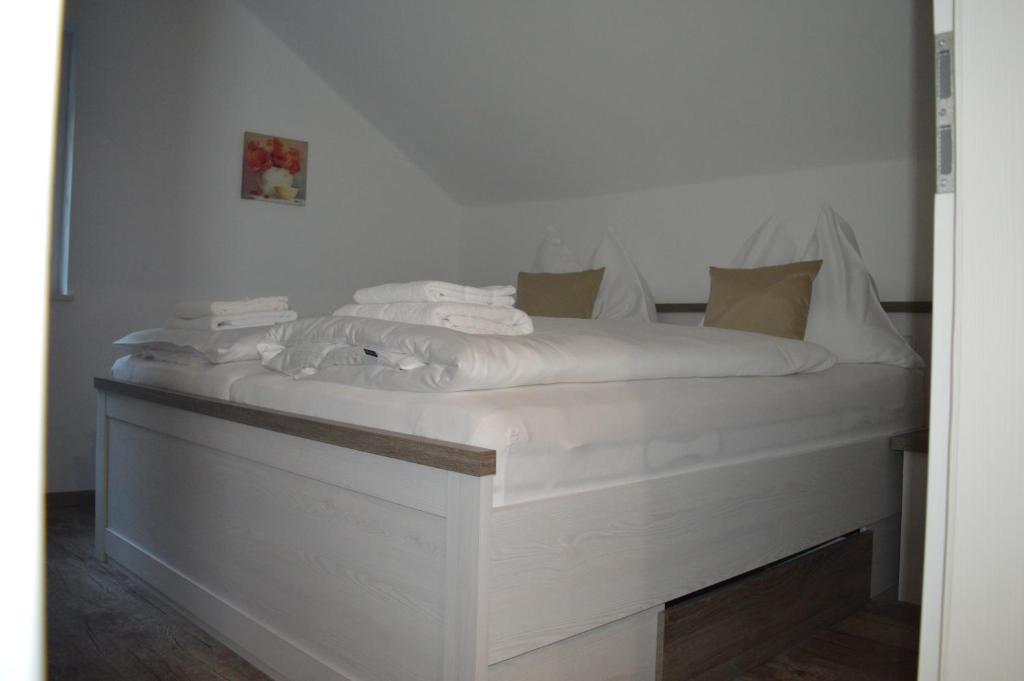 białe łóżko z białą pościelą i poduszkami w obiekcie Pension Kirchenwirt w mieście Bad Ischl