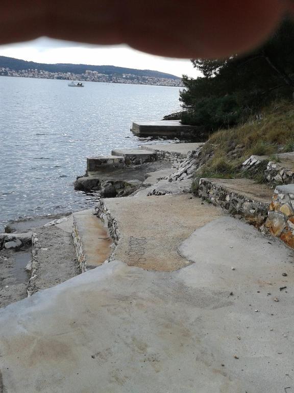 a beach with a body of water with a boat at Gogi apartman in Okrug Donji