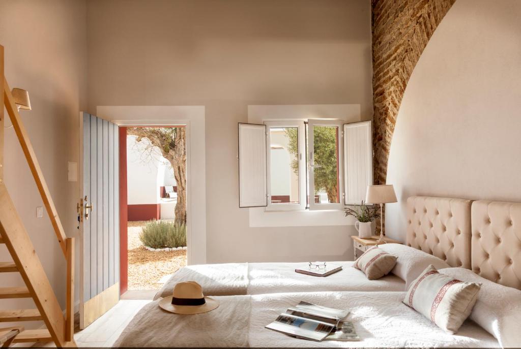 Un dormitorio con una cama grande y una ventana en Quinta da Chaminé en Ferreira do Alentejo