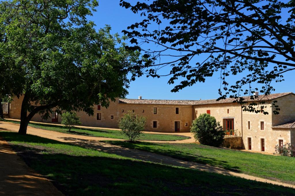 een oud gebouw met een boom op de voorgrond bij Chambres d'hôtes de Château Renon in Tabanac