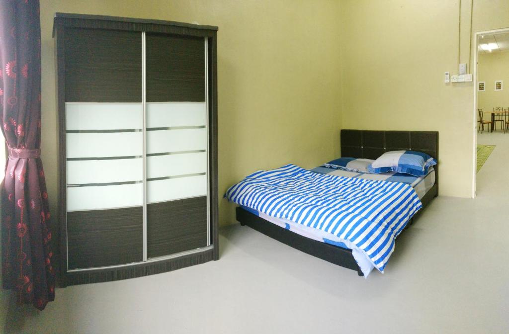 a bedroom with a bed and a large closet at Arau Guest House in Arau