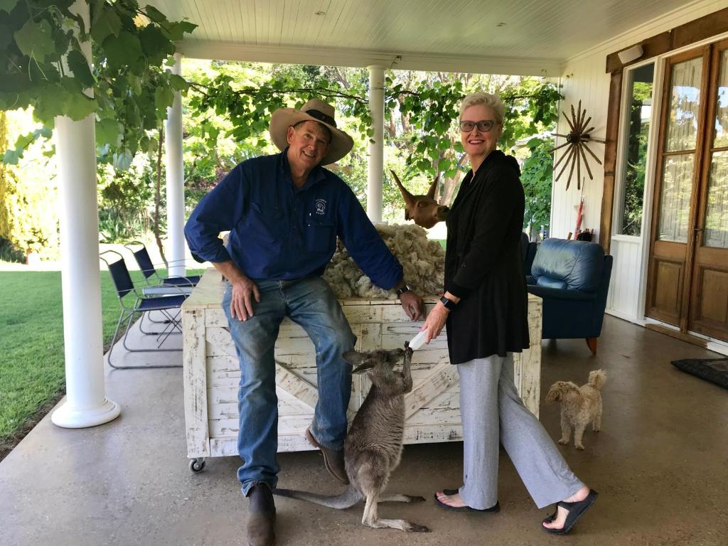 a man and a woman on a porch with a dog at Corynnia Station in Carrathool