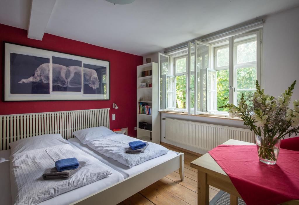 ワイマールにある"goethezimmer" Ferienwohnung und Zimmer am Burgplatzの赤い壁のベッドルーム1室(ベッド1台、テーブル付)