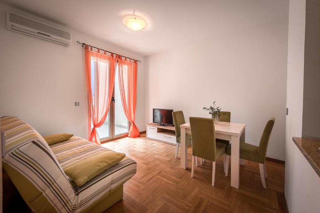 a living room with a table and a dining room at Apartments Montreal in Budva