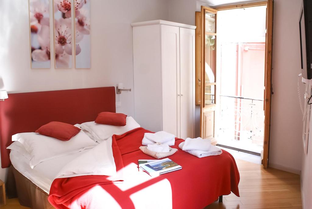 1 dormitorio con 1 cama con manta roja y blanca en Numero 3, en Cagliari