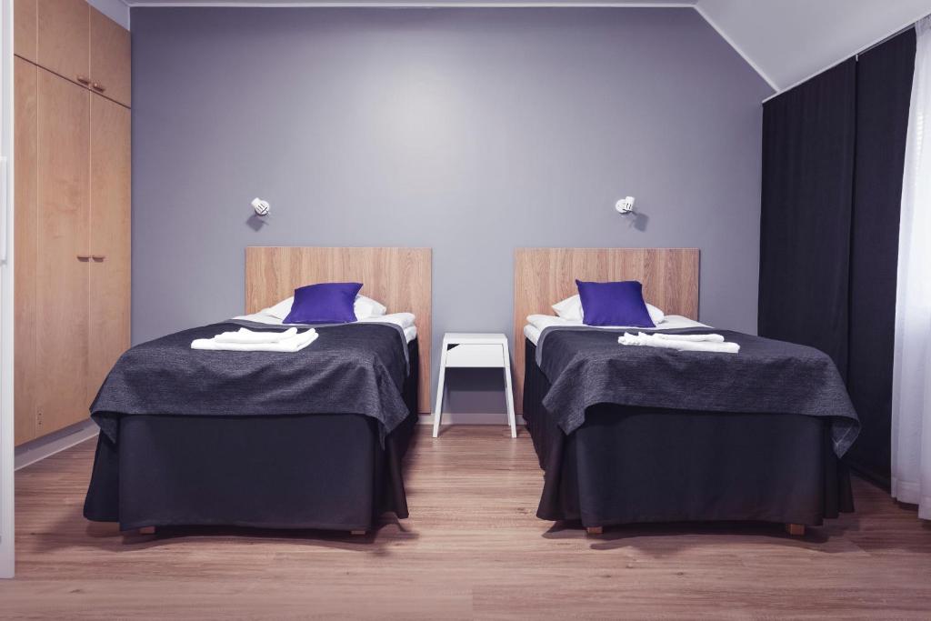 2 camas con almohadas azules en una habitación en Vuokatti Sport Resort en Vuokatti