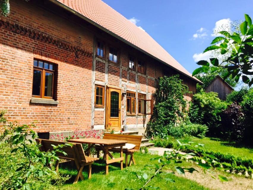 a brick house with a table and benches in the yard at Wilhelmshof Feggendorf in Feggendorf