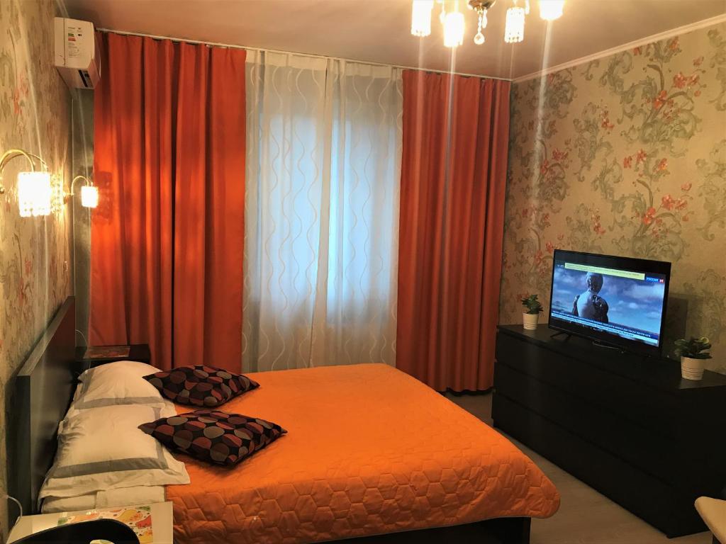 クラスノゴルスクにあるHotel Crocus Starのベッドルーム(ベッド1台、テレビ、カーテン付)