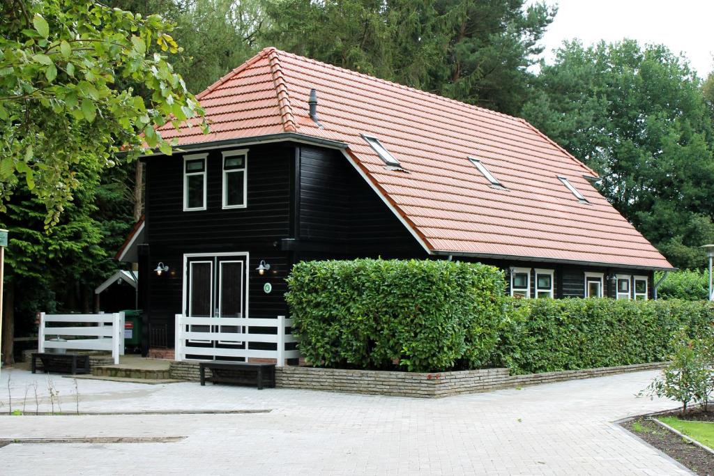 ein schwarzes Haus mit rotem Dach in der Unterkunft B&B "de Wingerd" in Bruchterveld