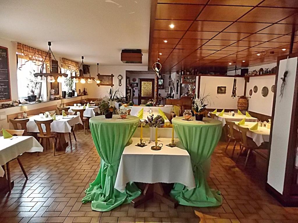 a restaurant with tables and chairs with green table cloth at Gasthof Goldener Stern in Aalen