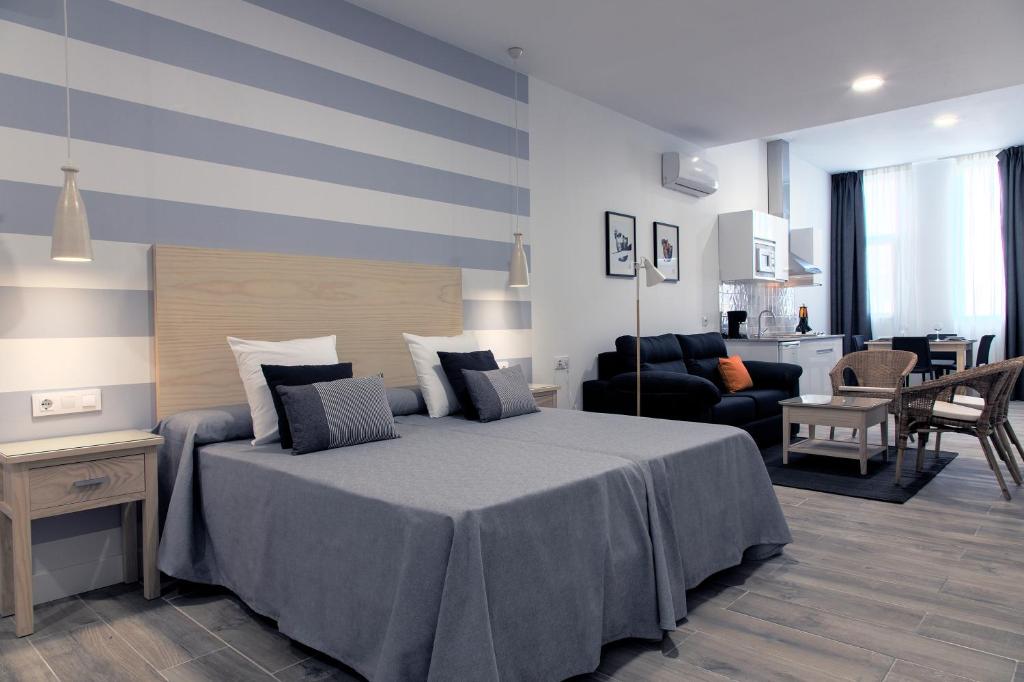 ein Schlafzimmer mit einem Bett und ein Wohnzimmer in der Unterkunft Hotel Apartamentos MPD in Merida