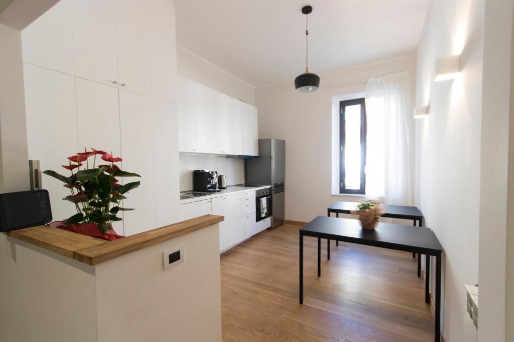 a kitchen with white cabinets and a table in a room at Colosseo Guest House in Rome