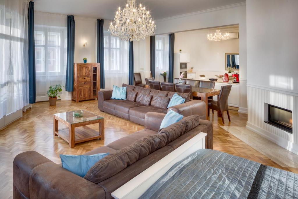 uma grande sala de estar com um sofá e uma mesa em Smetanovo nábřeží 26 - Riverview Old Town Apartment em Praga
