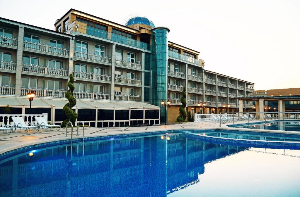 a hotel with a swimming pool in front of a building at Ribera Resort&SPA in Yevpatoriya