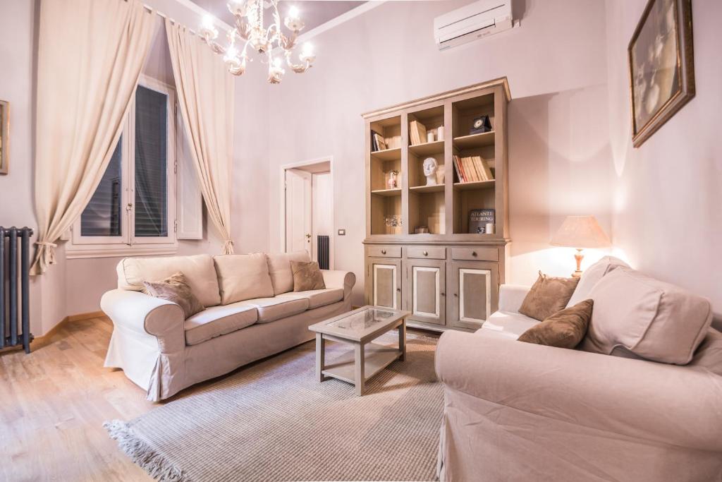 uma sala de estar com dois sofás e um lustre em Stunning Apt 5min Walk to Duomo em Florença