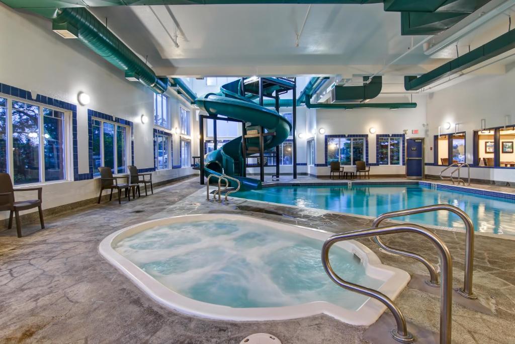 a jacuzzi tub in a pool with a slide at Canalta Rocky Mountain House in Rocky Mountain House
