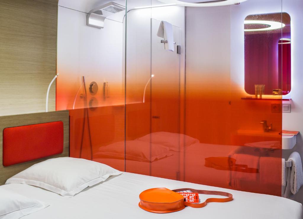 a bedroom with a glass shower and a bed at Hôtel Odyssey in Paris