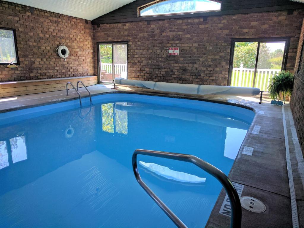 a large swimming pool with blue water in a house at Hop & Vine Inn in Fennville