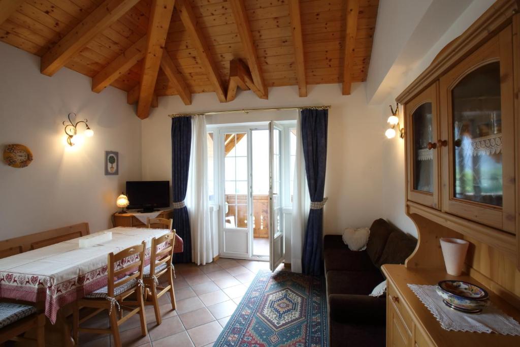 una sala de estar con mesa y sillas y una habitación en Casa Rubino Lake & Dolomites, en Molveno