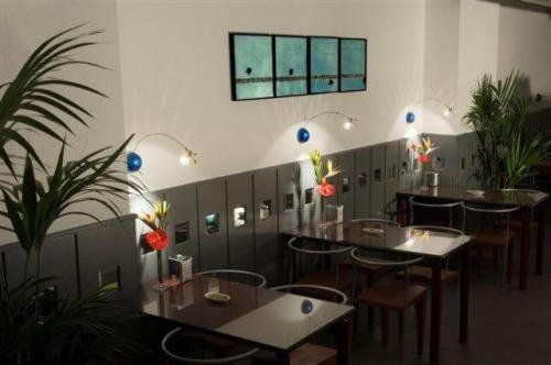 a dining room with tables and chairs and plants at Hotel Nautico in Santa Cruz de Tenerife