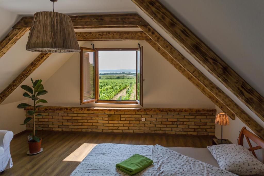a room with a bed and a window with a view at Tagyon Birtok Mandula Apartmanház in Tagyon