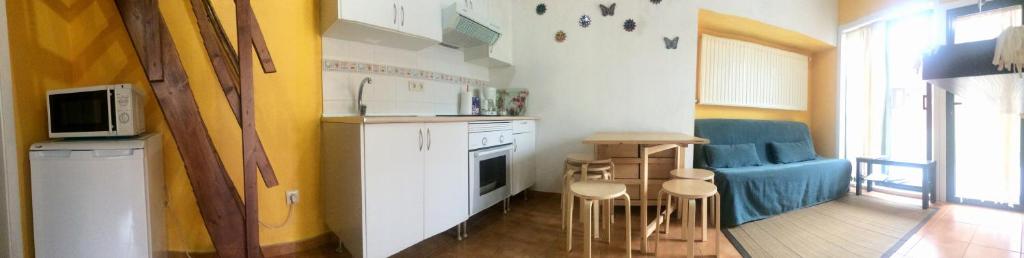 a kitchen with a table and chairs in a room at Los Tres Soles in Silleda