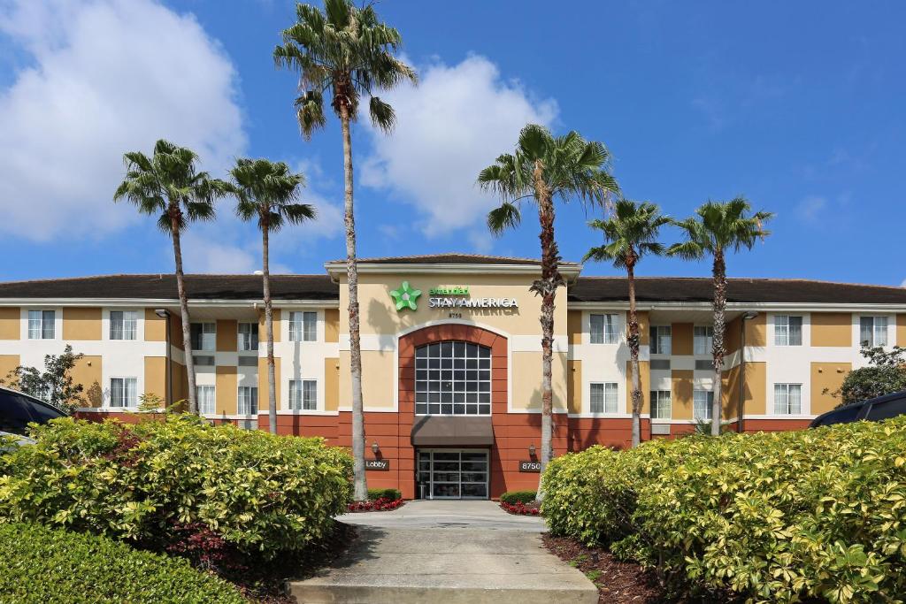 a hotel with palm trees in front of a building at Extended Stay America Suites - Orlando - Convention Center - Universal Blvd in Orlando